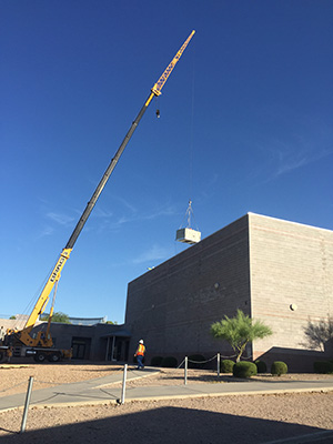 Crane lifing HVAC unites onto roof